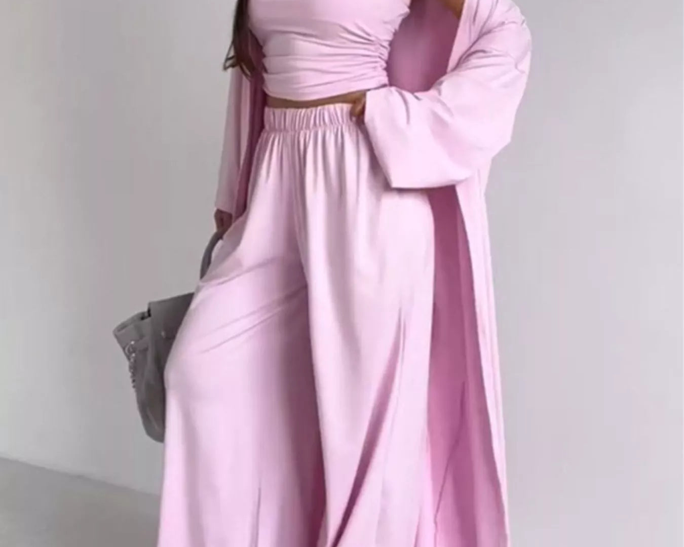 NEWYORKLISTED COMFORT COLLECTION: Woman wearing a pink outfit with a long cardigan on a white background
