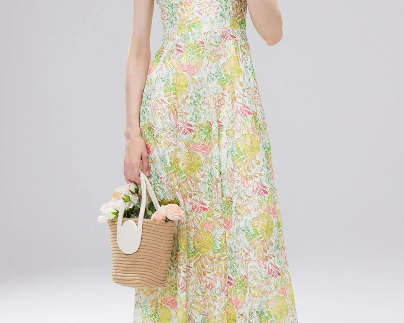 NEWYORKLISTED STYLE COLLECTION: Woman wearing a floral dress holding a straw bag with flowers on a white background