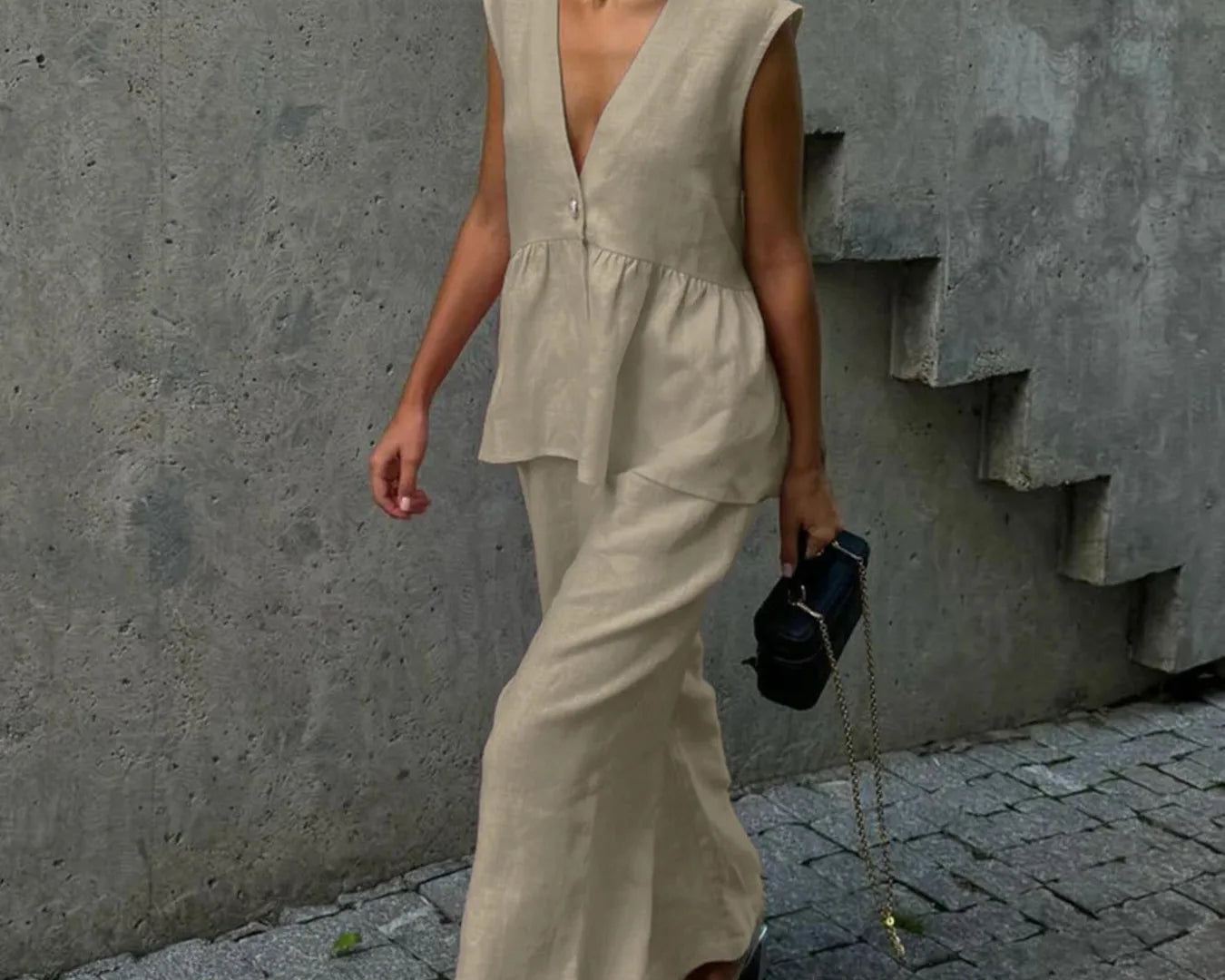 NEWYORKLISTED STYLE COLLECTION: Woman in a beige sleeveless top and wide-leg pants walking on a street.