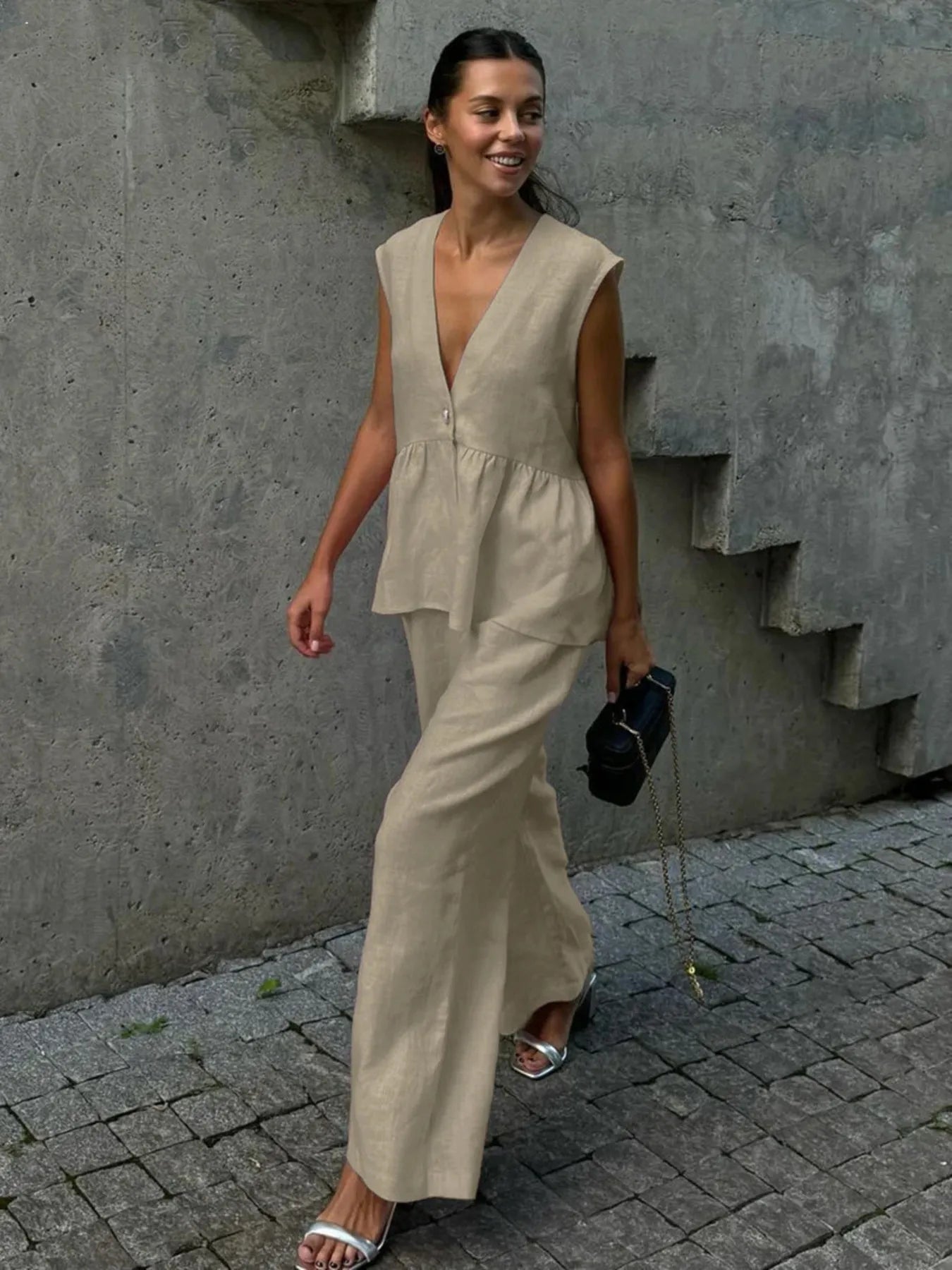 NEWYORKLISTED STYLE COLLECTION: Woman in a beige sleeveless top and wide-leg pants walking on a street.