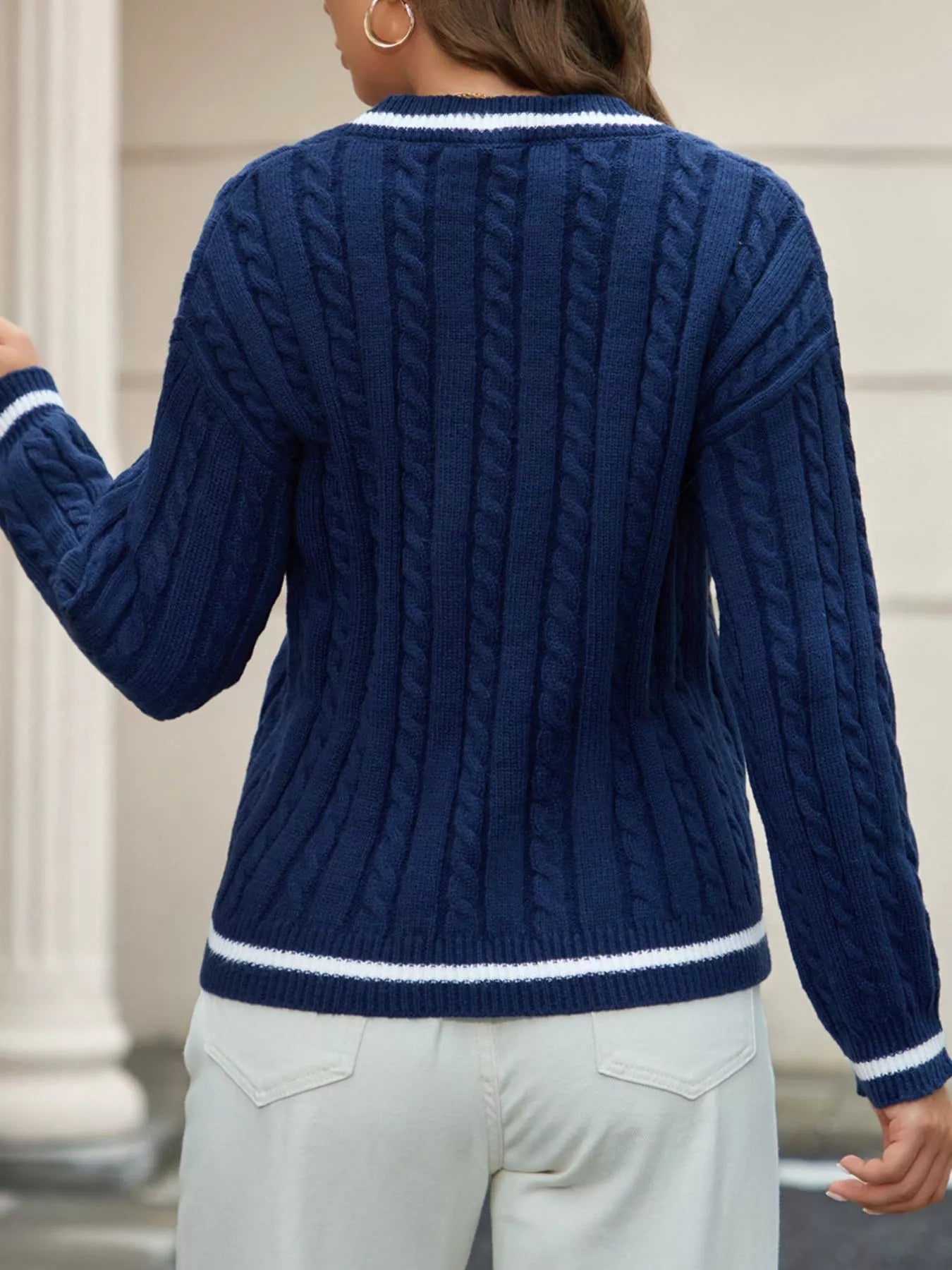 NEWYORKLISTED STYLE COLLECTION: Person wearing a blue cable knit sweater with white trim