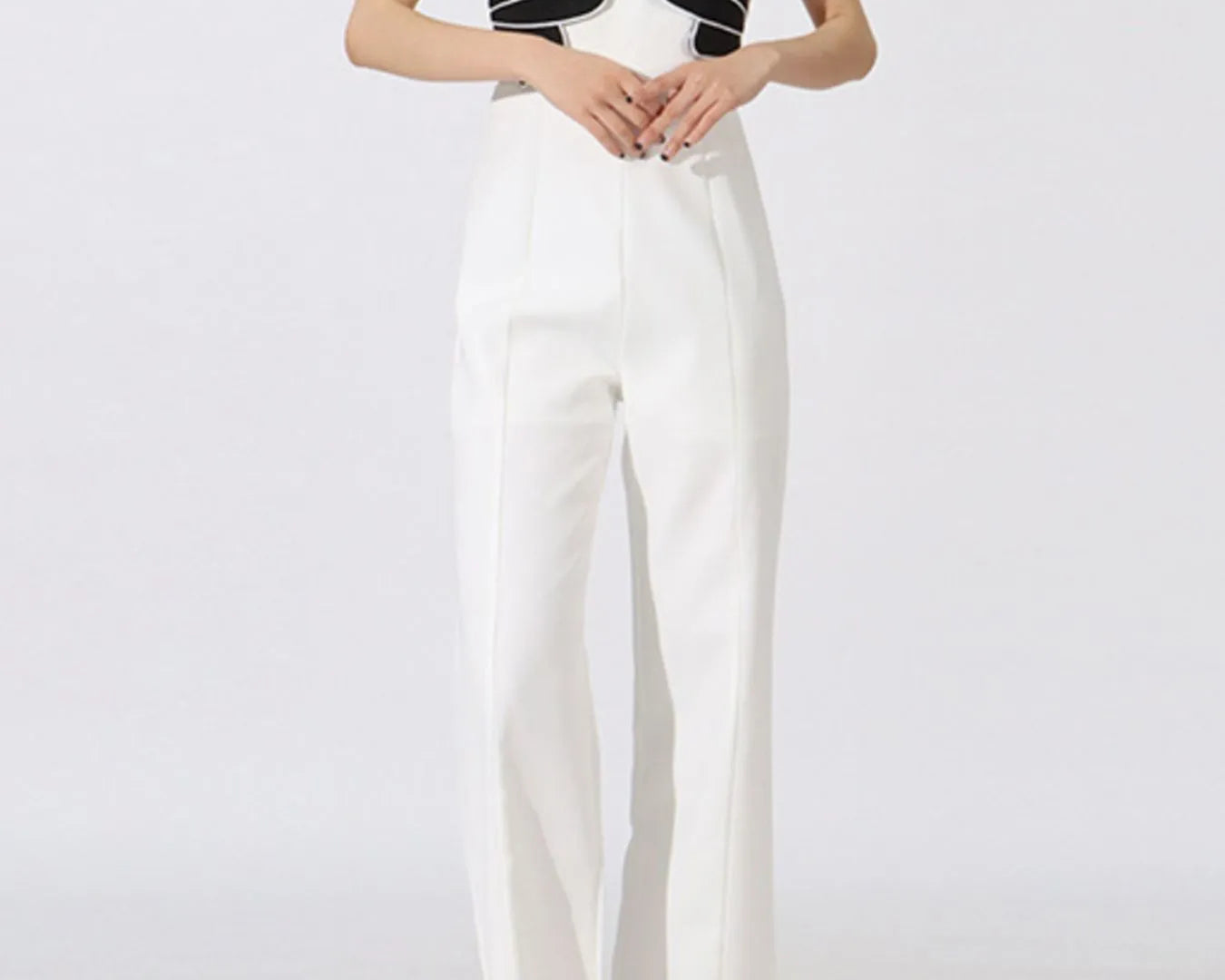 NEWYORKLISTED: Woman wearing a black and white outfit with a unique top design on a white background