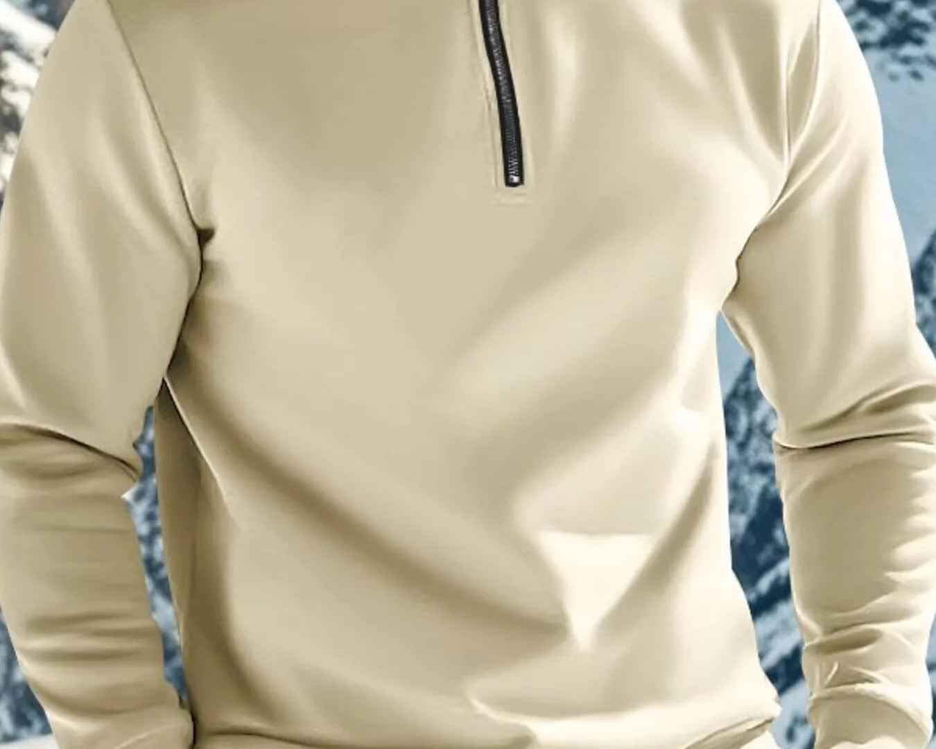 NEWYORKLISTED ATLAS MEN'S COLLECTION: Person wearing a beige pullover with a mountainous background