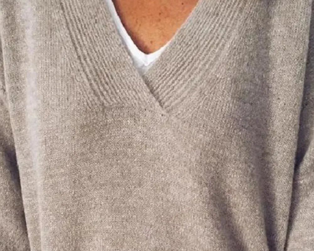 NEWYORKLISTED STYLE COLLECTION: Close-up of a person wearing a beige sweater over a white shirt.