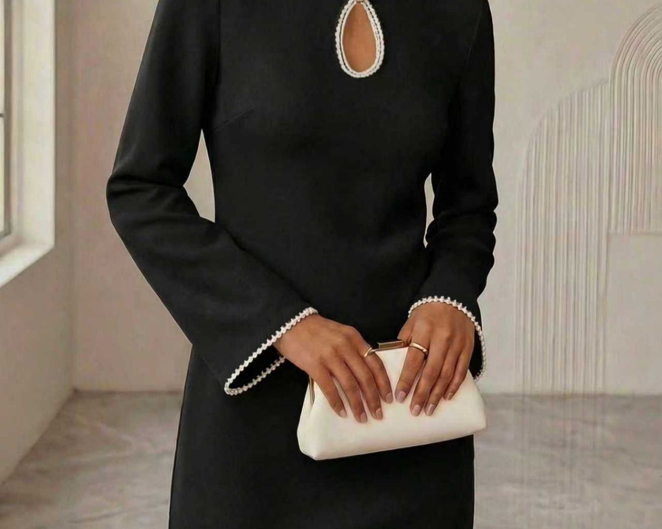 Woman wearing a NEWYORKLISTED STYLE COLLECTION keyhole pearl trim mini dress with elegant pearl neckline detail and polished evening style