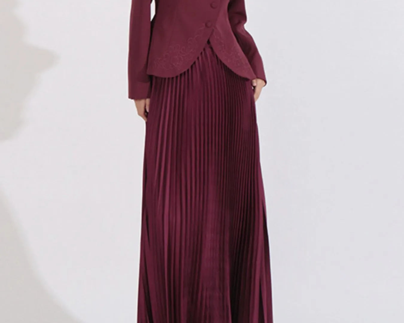 NEWYORKLISTED STYLE COLLECTION: Maroon suit with a jacket and pleated skirt on a white background