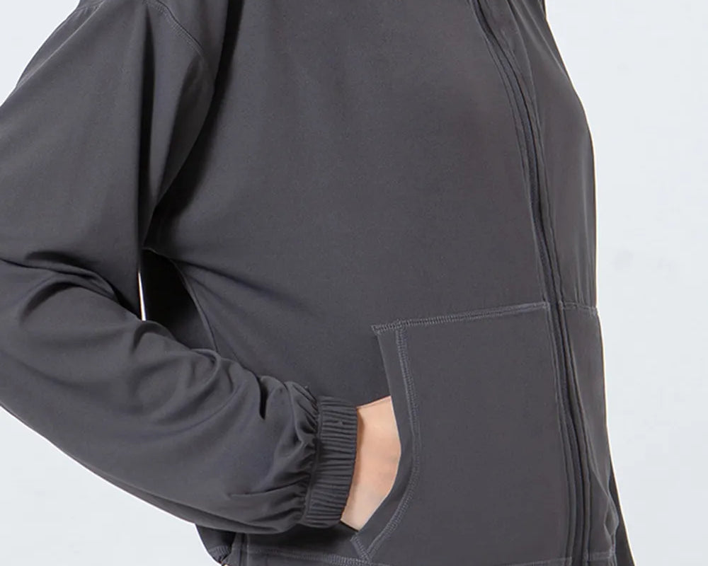 NEWYORKLISTED ACTIVEWEAR COLLECTION: Person wearing a dark gray jacket with a white background