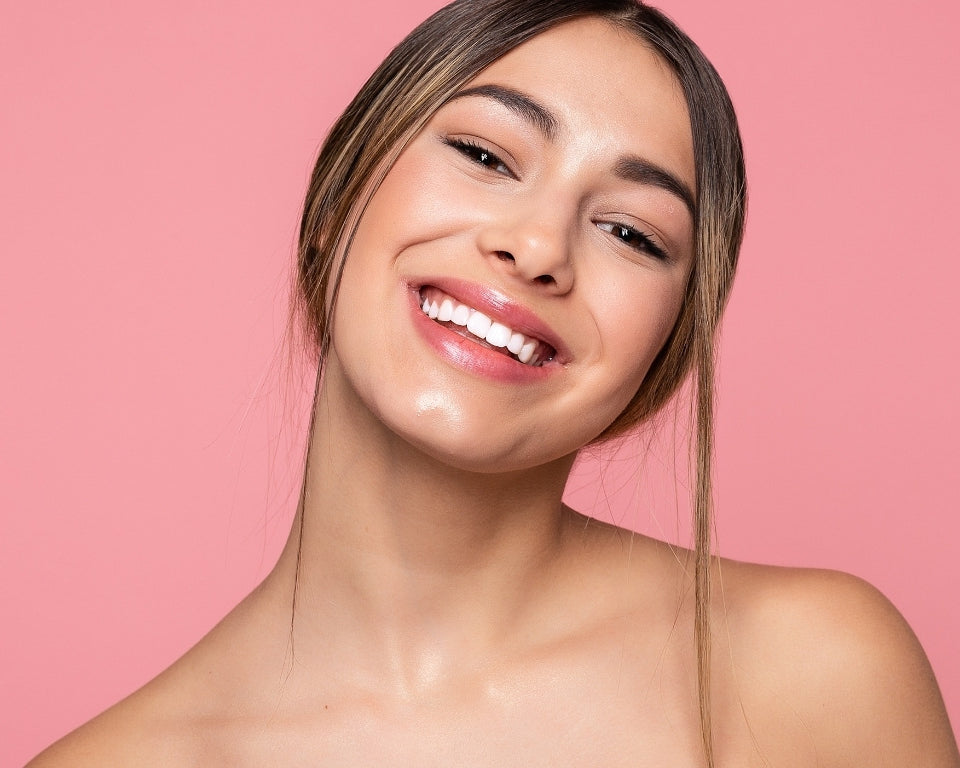 NEWYORKLISTED COSMETIC COLLECTION: Extreme Moisture Blend: Woman with a radiant smile against a pink background