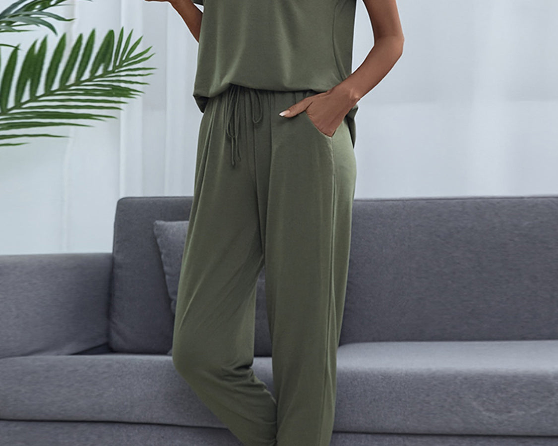 NEWYORKLISTED Intimate Apparel: Person wearing a green pajama set sitting on a gray couch.