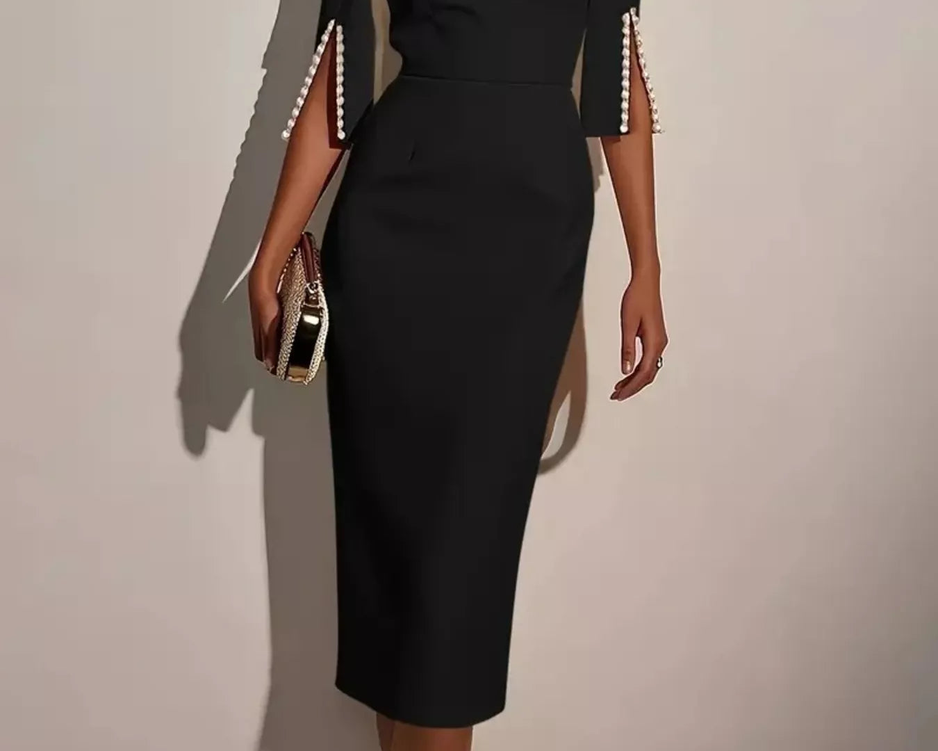 NEWYORKLISTED STYLE COLLECTION: Black dress with pearl embellishments on sleeves against a plain background
