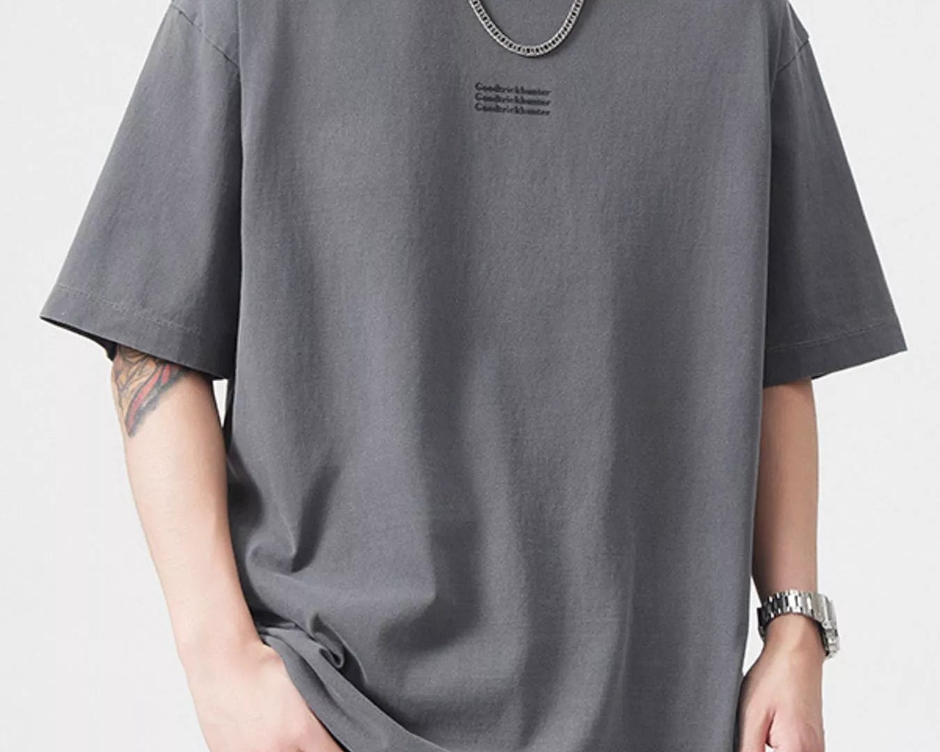 NEWYORKLISTED ATLAS MEN's COLLECTION: Person wearing a gray t-shirt with a small logo on a white background