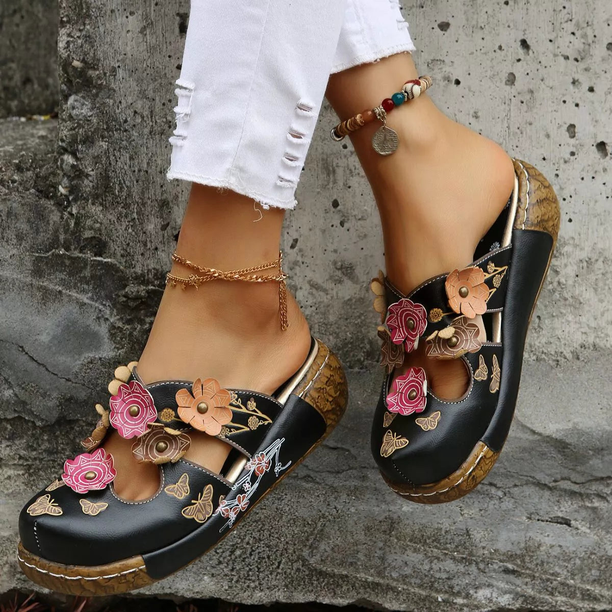 NEWYORKLISTED SHOE COLLECTION: Black floral embroidered sandals on a stone surface