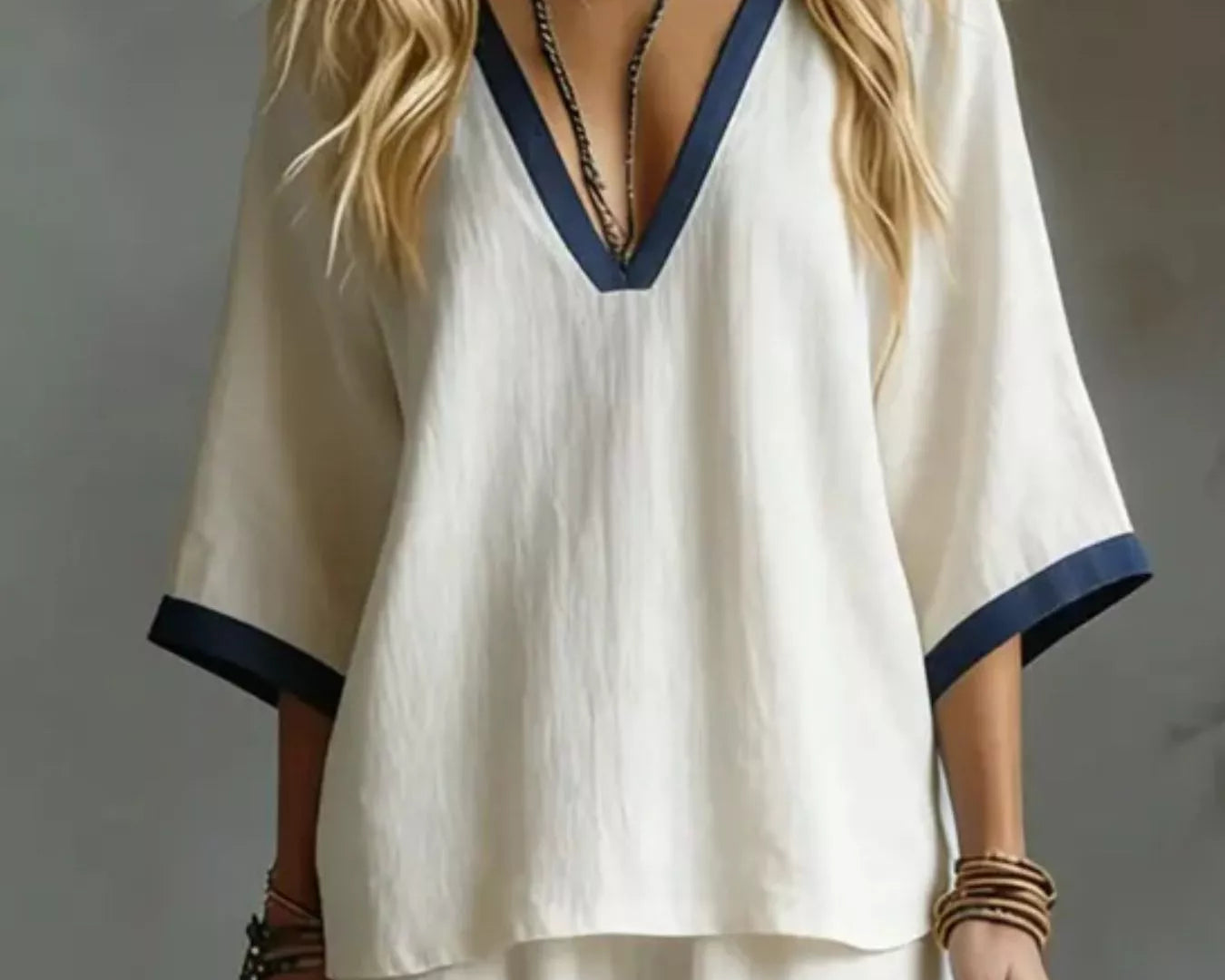 NEWYORKLISTED STYLE COLLECTION: Woman wearing a white outfit with blue trim against a neutral background