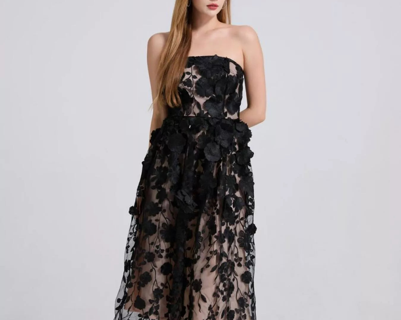 NEWYORKLISTED STYLE COLLECTION: Woman wearing a black floral strapless dress on a white background