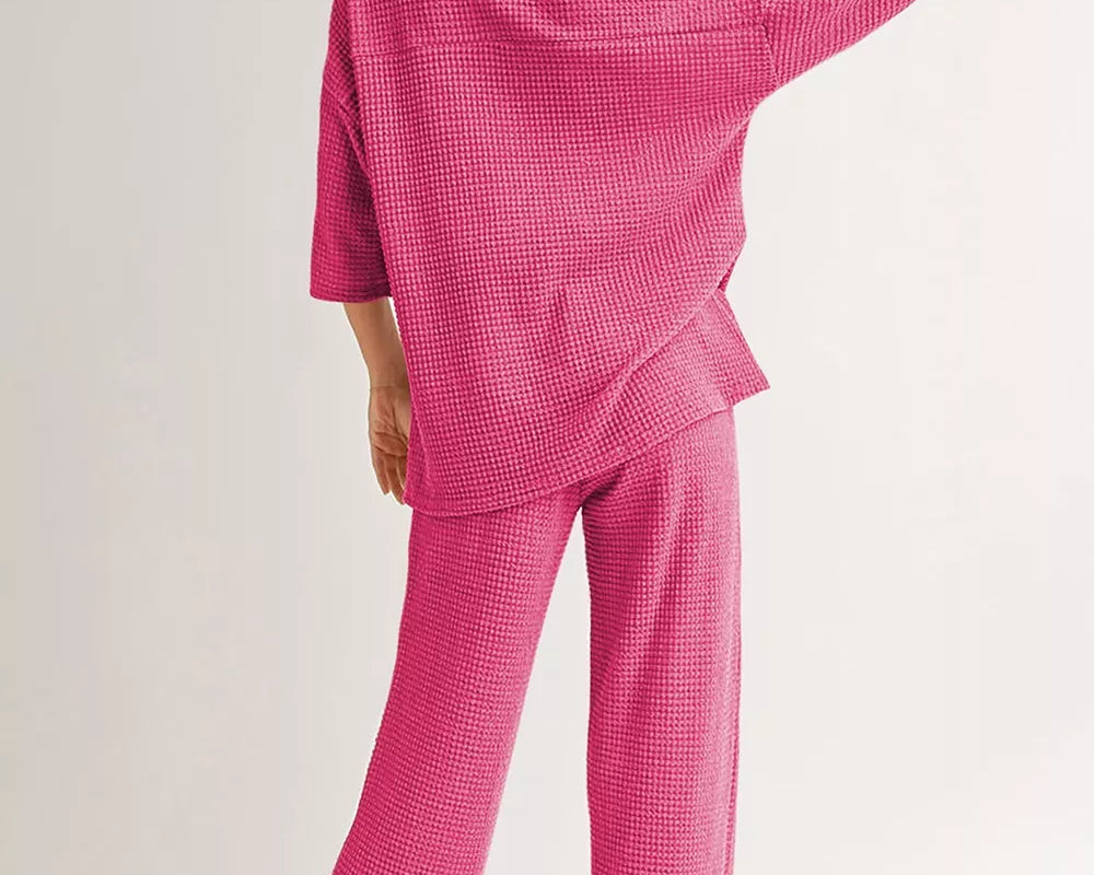 NEWYORKLISTED Comfort Collection: Person wearing a pink checkered pajama set on a plain background