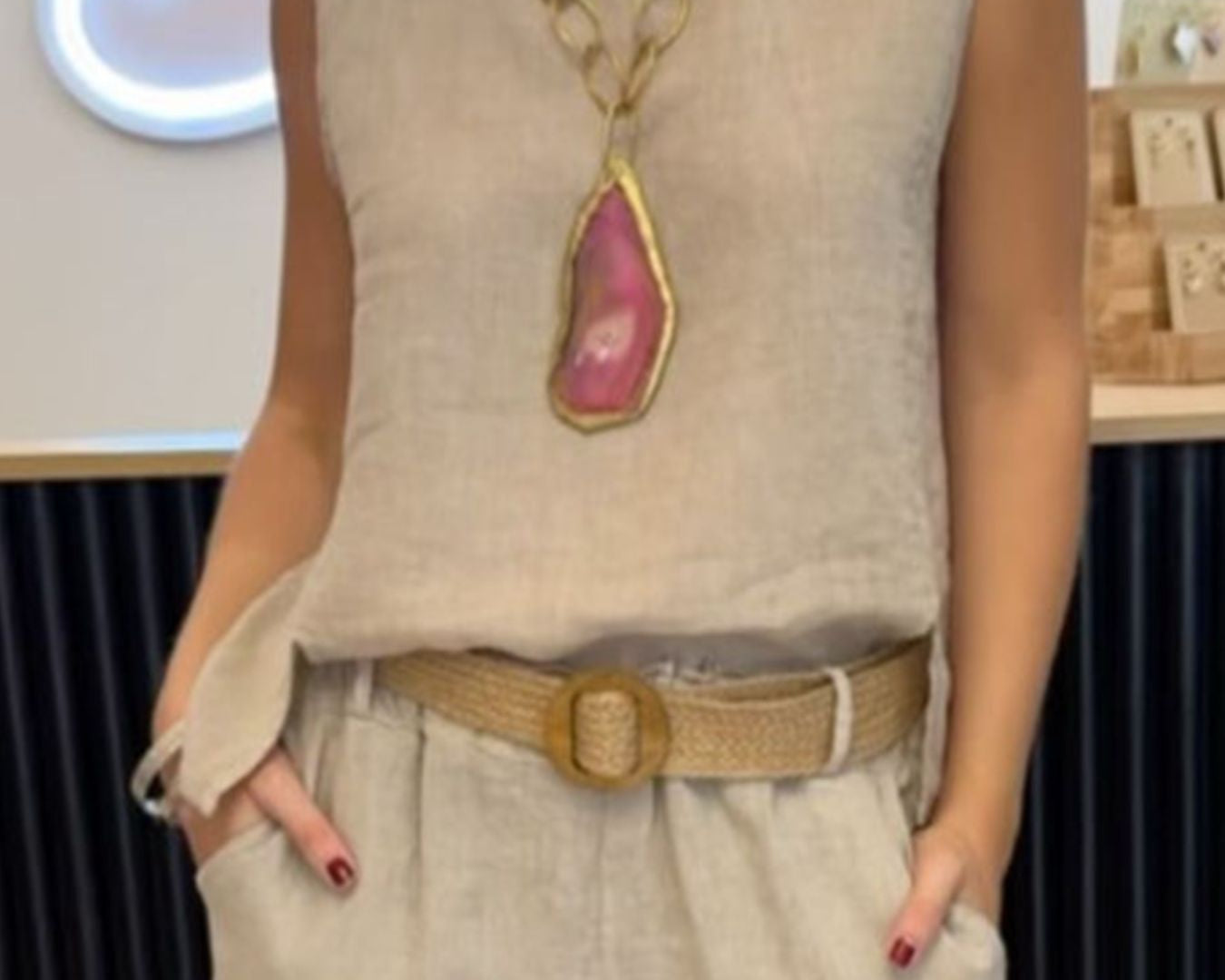 NEWYORKLISTED COMFORT COLLECTION: Person wearing a beige sleeveless top with a large necklace and beige pants in an indoor setting.