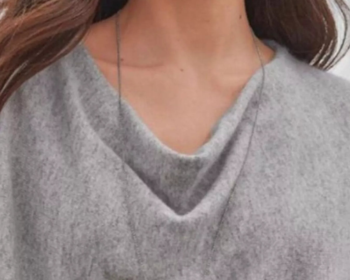 NEWYORKLISTED STYLE COLLECTION: Woman wearing a gray sweater with a draped neckline