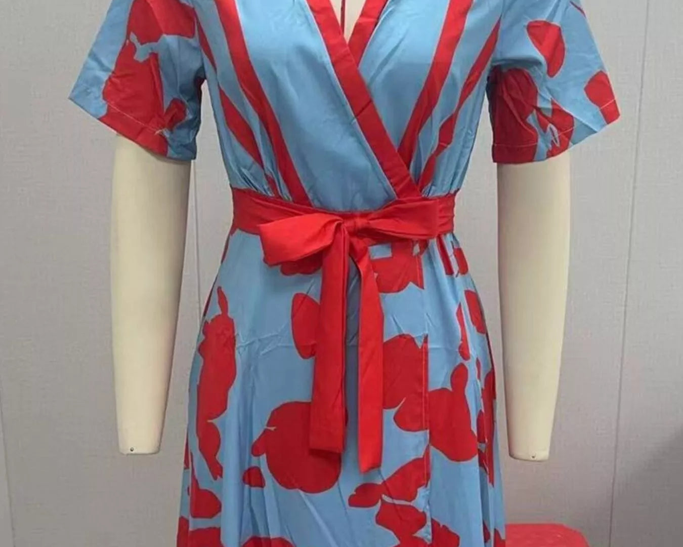 NEWYORKLISTED STYLE COLLECTION: Red and blue patterned dress on a mannequin against a plain background