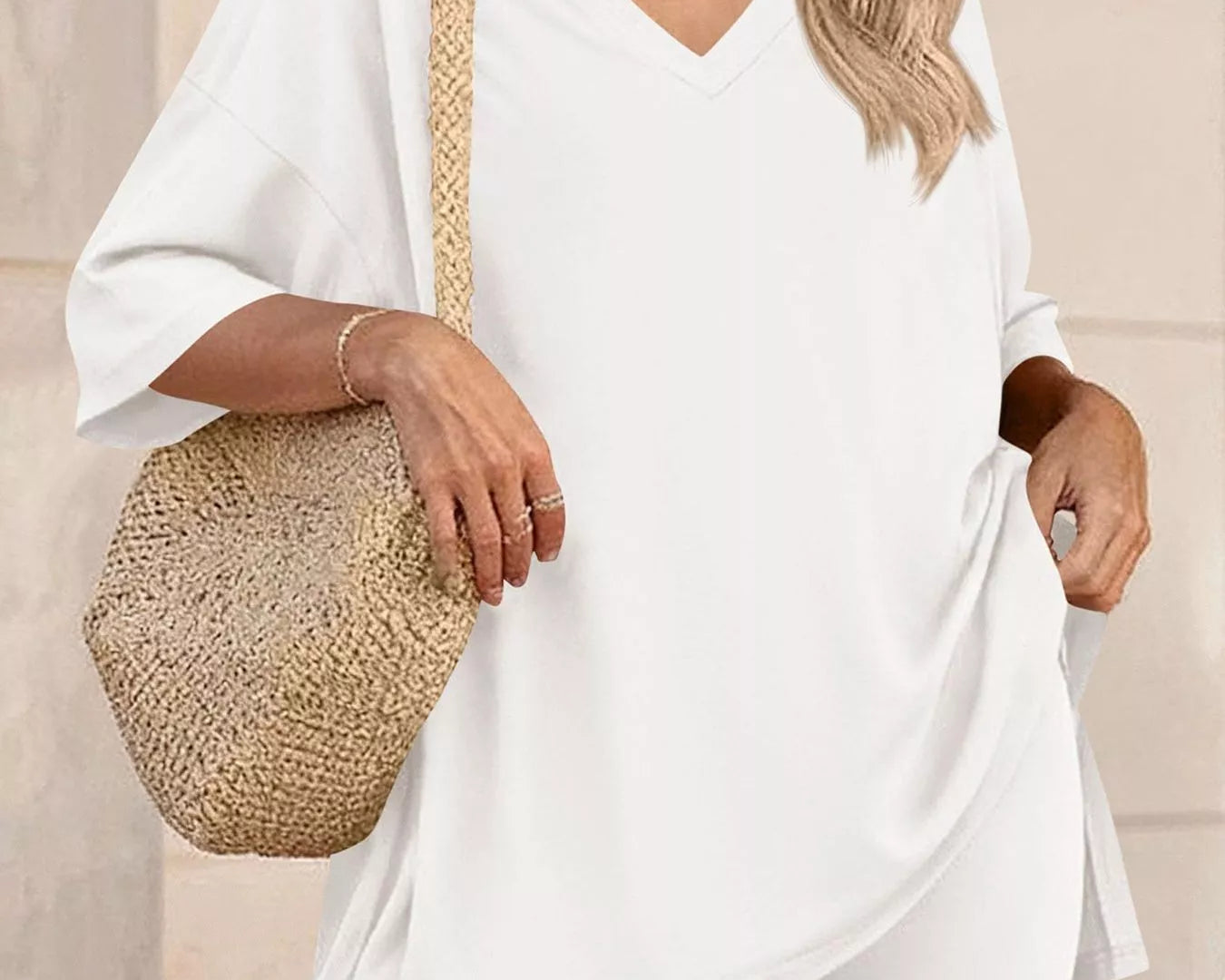 NEWYORKLISTED COMFORT COLLECTION: Woman wearing a white outfit with a straw bag against a neutral background