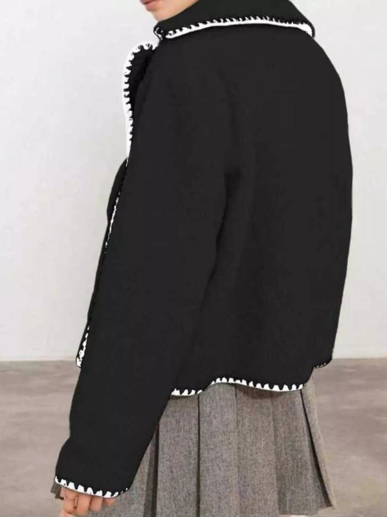 NEWYORKLISTED STYLE COLLECTION: Black jacket with white trim on a plain background