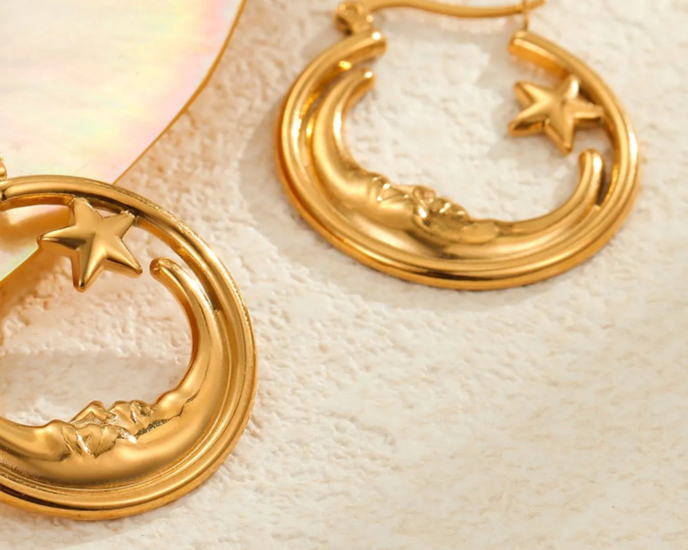 Gold hoop earrings with star and moon designs on a light background - NEWYORKLISTED STYE COLLECTION
