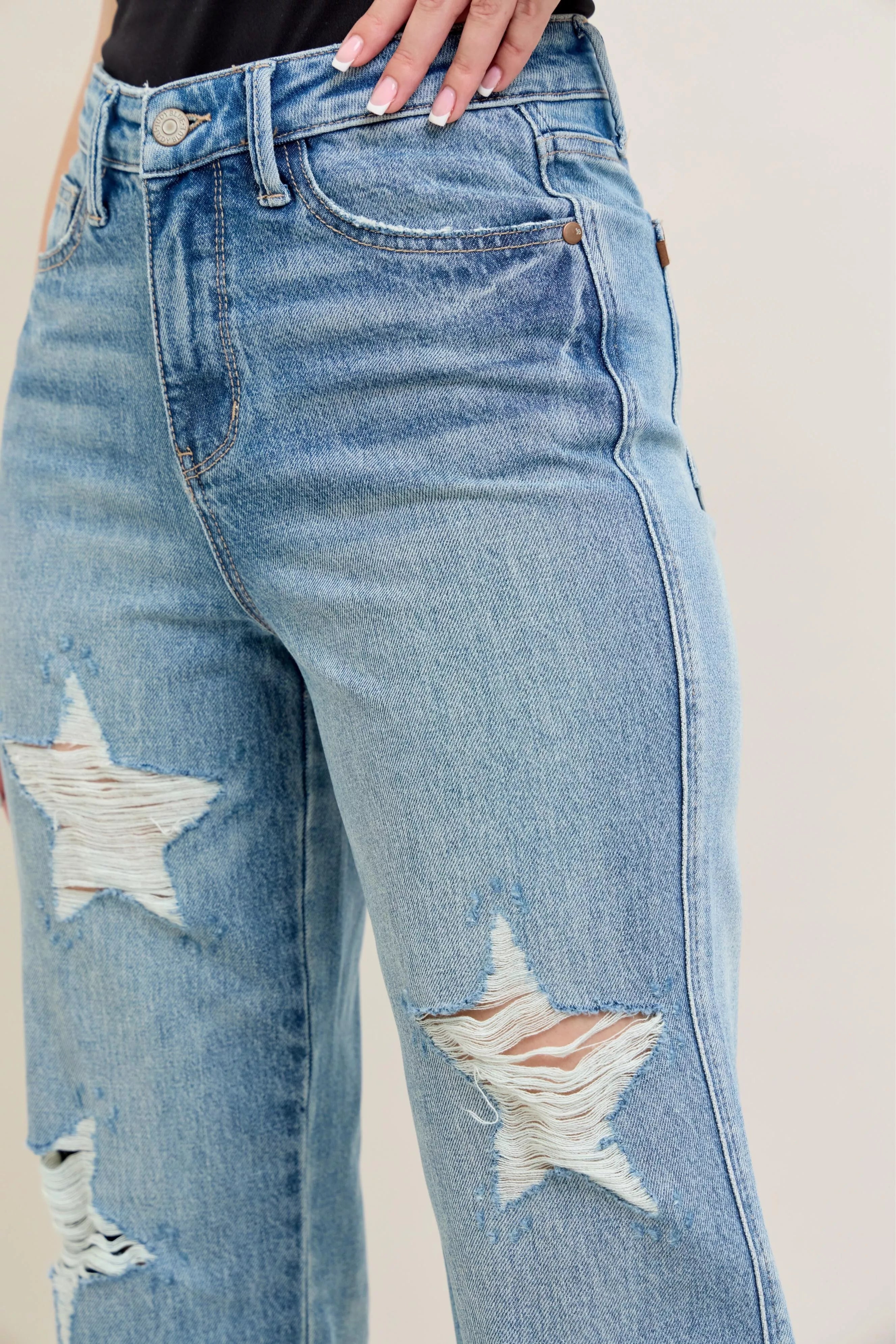 NEWYORKLISTED STYLE COLLECTION: Blue jeans with star designs on a plain background