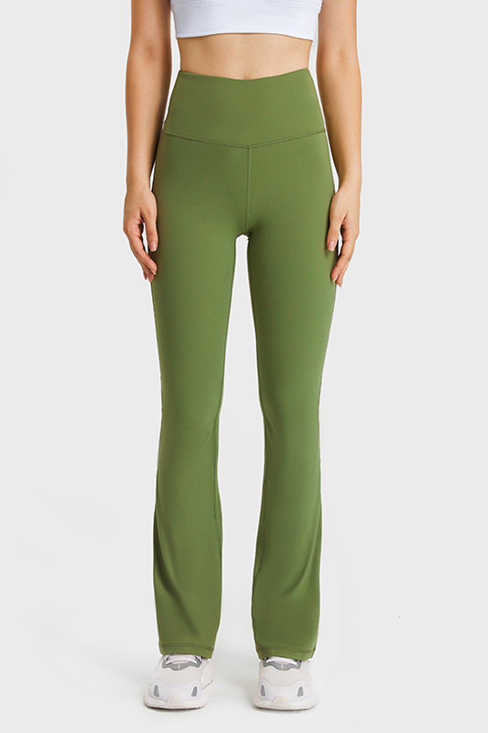 NEWYORKLISTED ACTIVEWEAR COLLECTION: Person wearing green leggings and white top on a plain background