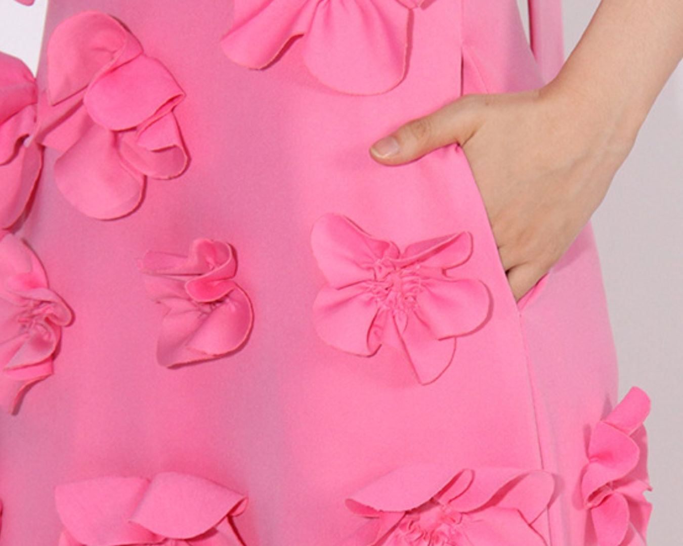 NEWYORKLISTED STYLE COLLECTION: Close-up of a pink dress with floral patterns on a plain background