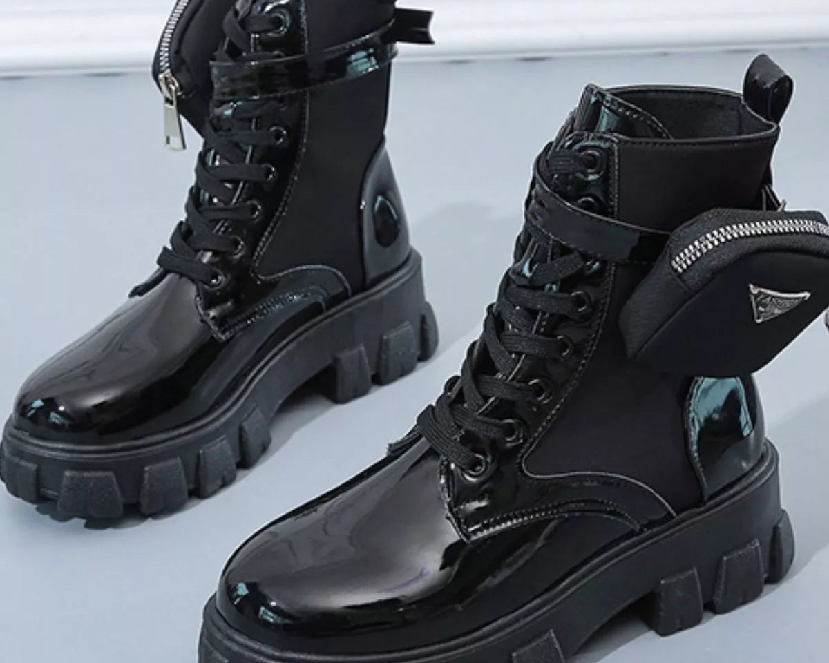 NEWYORKLISTED SHOE COLLECTION: Black glossy combat boots with thick soles on a light gray background