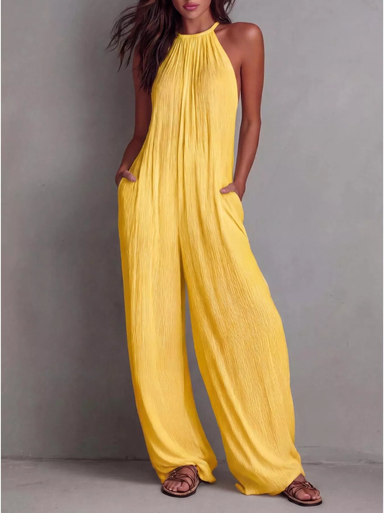 NEWYORKLISTED STYLE COLLECTION: Woman wearing a yellow jumpsuit against a gray background