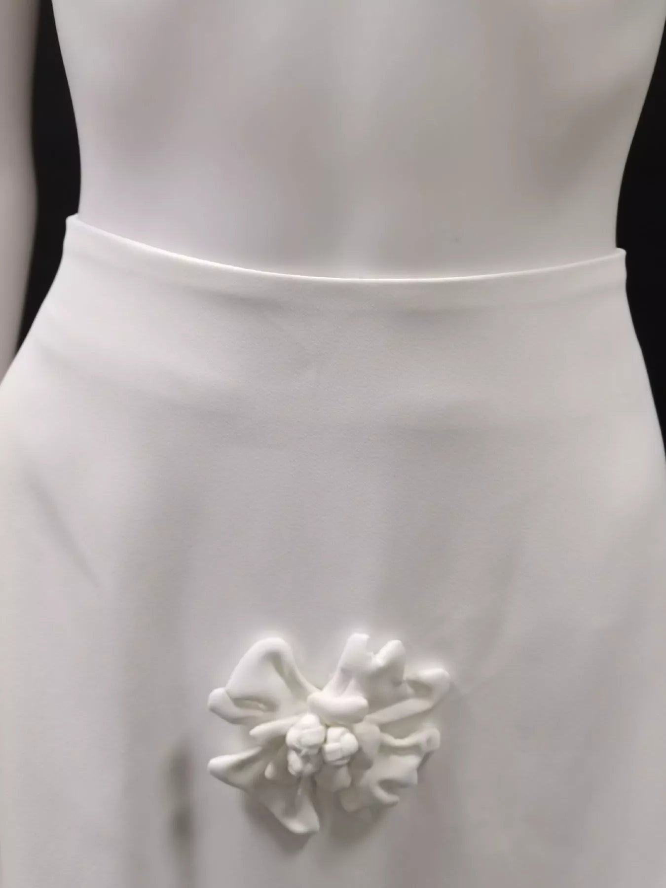 NEWYORKLISTED STYLE COLLECTION: White dress with a decorative floral brooch on a black background
