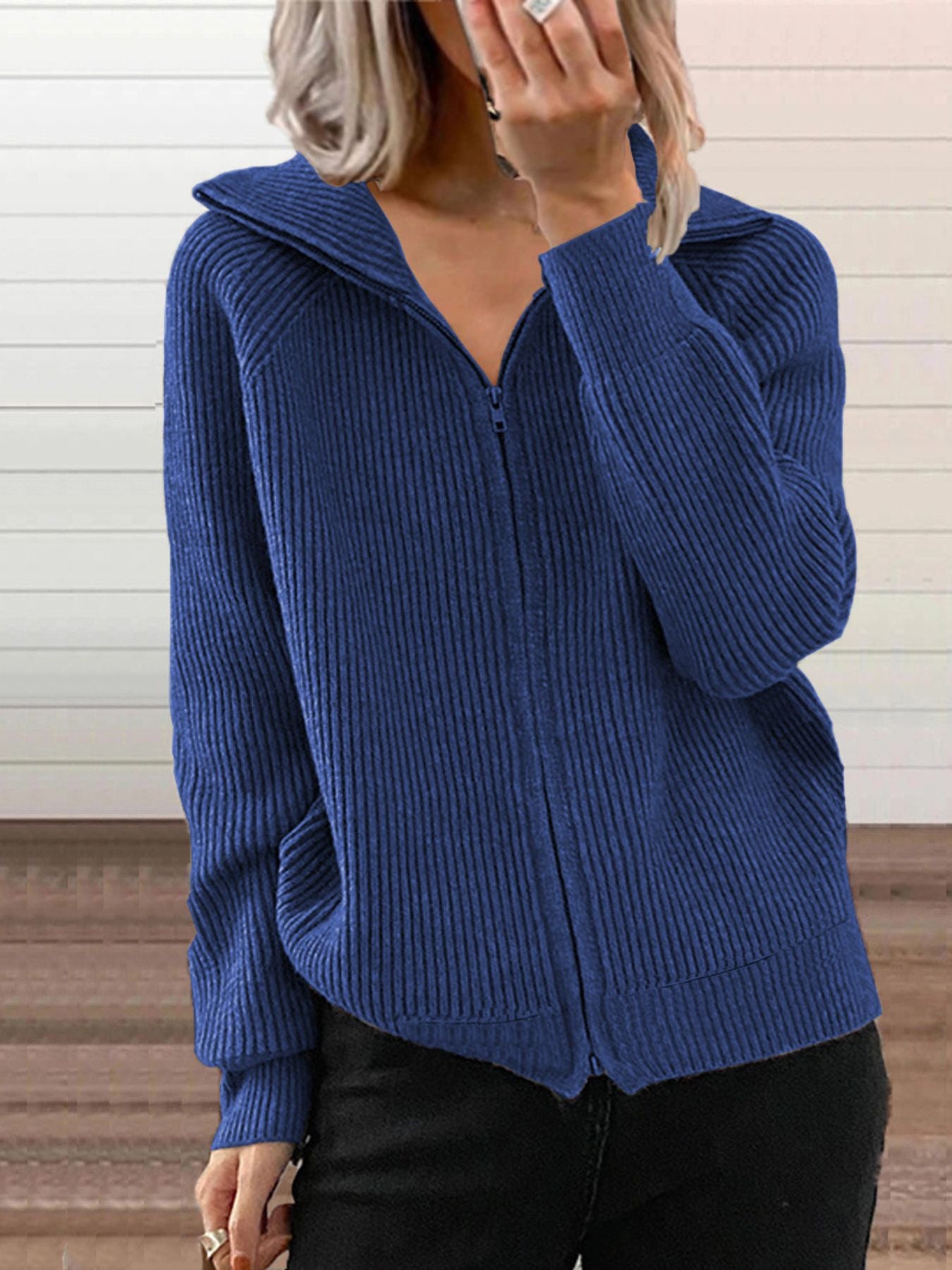 NEWYORKLISTED STYLE COLLECTION: Person wearing a blue ribbed zip-up sweater against a neutral background
