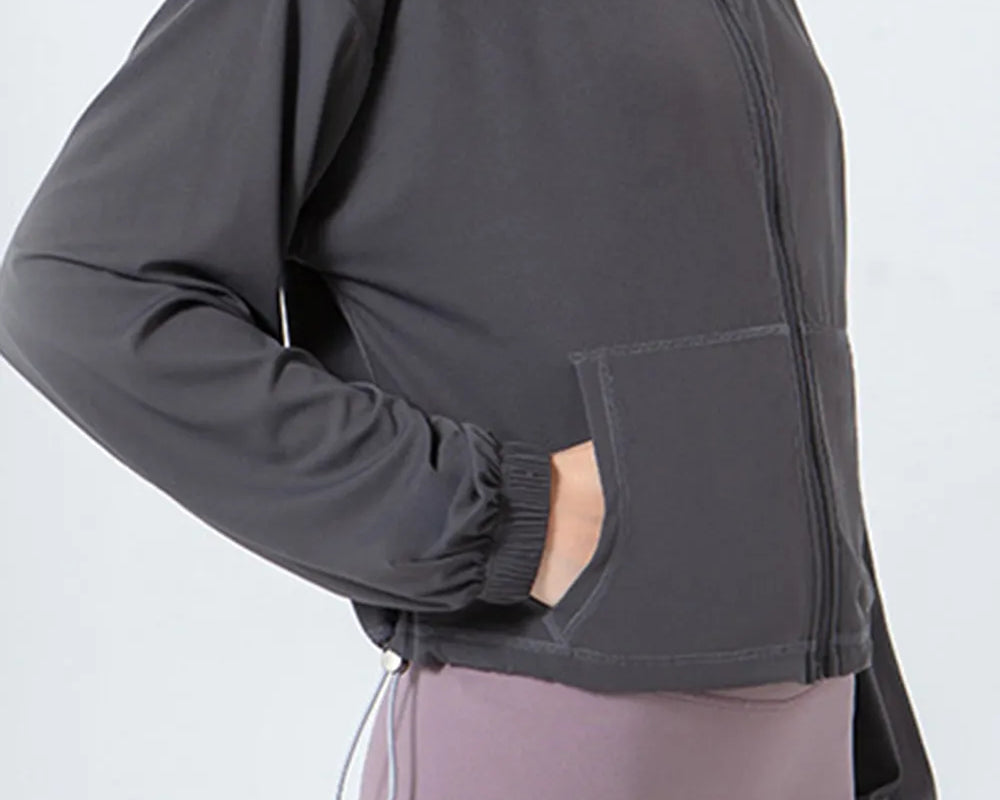 NEWYORKLISTED ACTIVEWEAR COLLECTION: Person wearing a dark gray jacket and light purple leggings on a white background