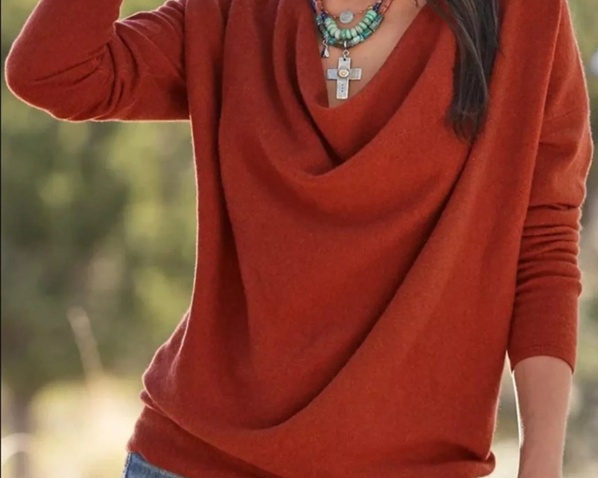 NEWYORKLISTED STYLE COLLECTION: Person wearing a rust-colored sweater and blue jeans with a blurred natural background