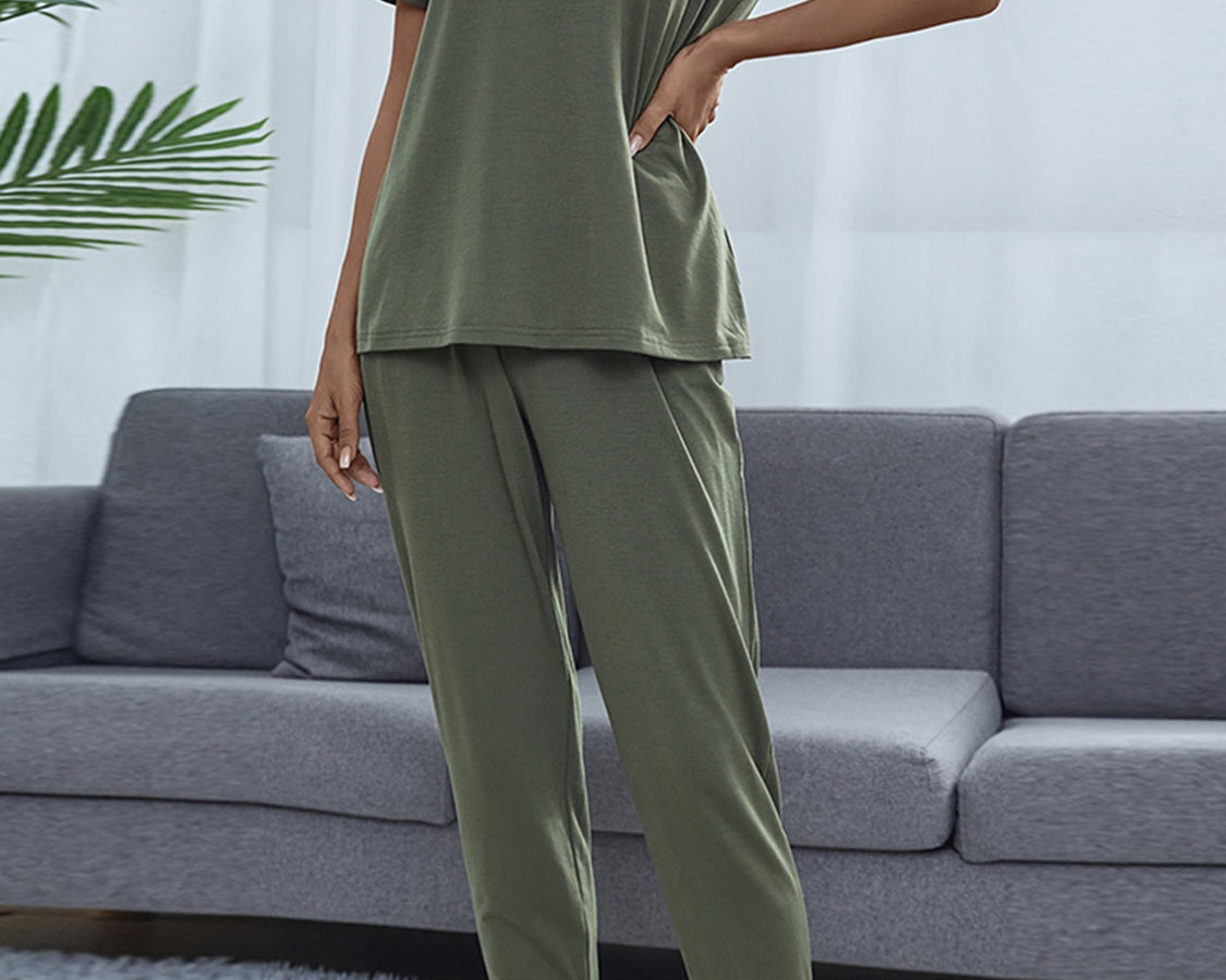 NEWYORKLISTED Intimate Apparel: Person wearing a green pajama set standing in front of a gray sofa.