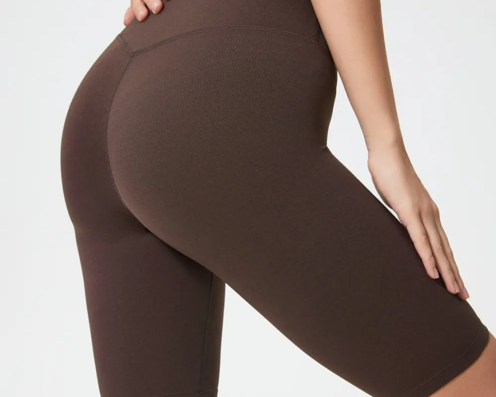 Brown athletic shorts worn by a person on a white background