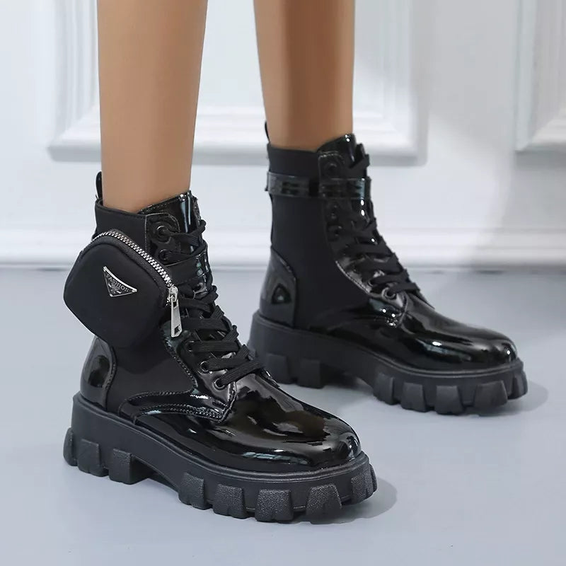 NEWYORKLISTED SHOE COLLECTION: Black patent leather boots with zippers on a neutral background