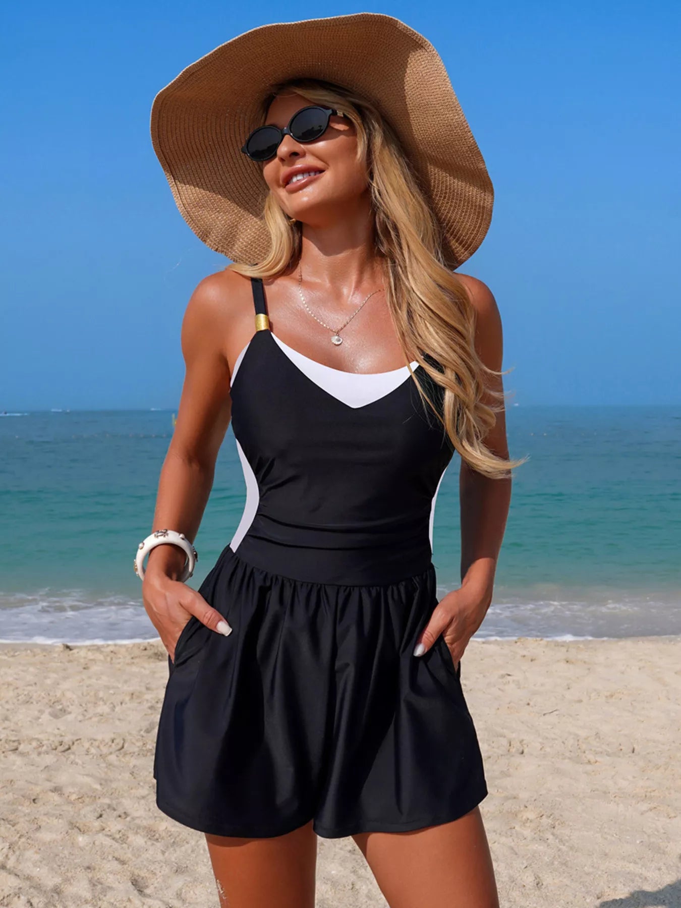 NEWYORKLISTED EDEN COLLECTION: Woman in black dress and sun hat on a beach