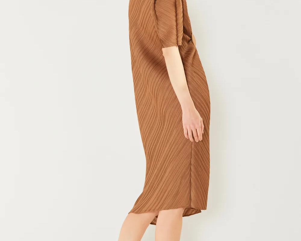 Woman wearing a brown dress against a white background: NEWYORKLISTED STYLE COLLECTION