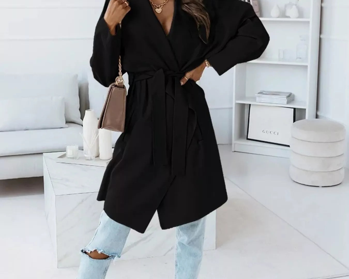 NEWYORKLISTED STYLE COLLECTION: Woman wearing a black coat in a modern living room