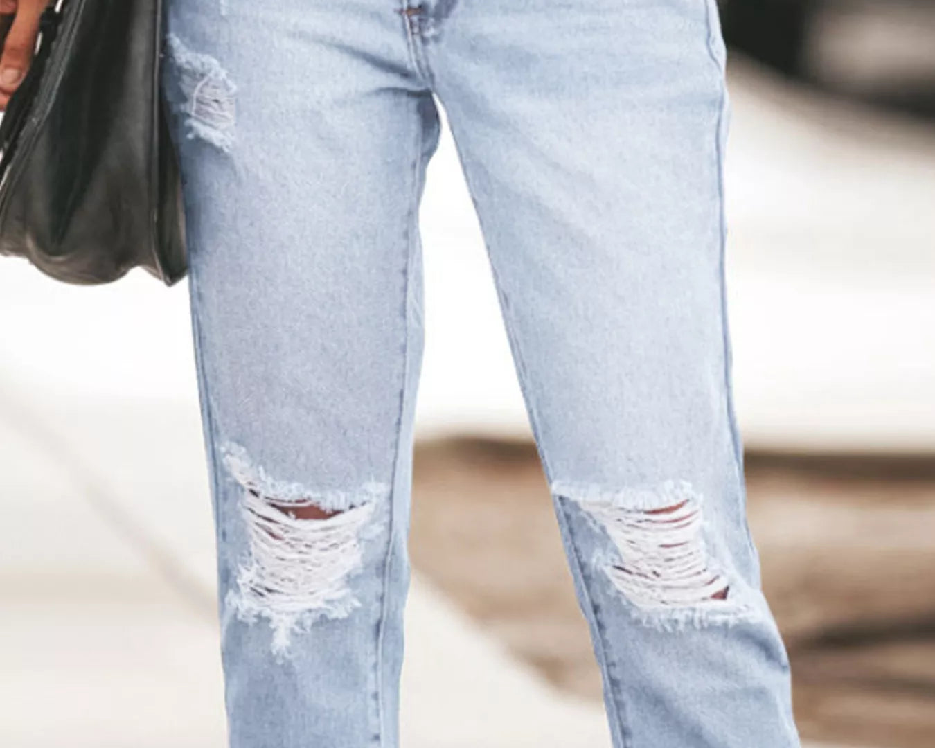 NEWYORKLISTED STYLE COLLECTION: Light blue ripped jeans worn by a person with a blurred background