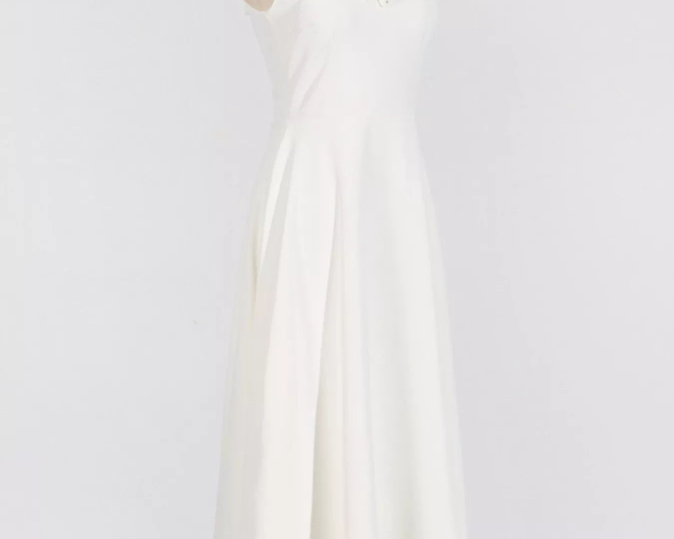 NEWYORKLISTED STYLE COLLECTION: White dress on a mannequin against a plain background