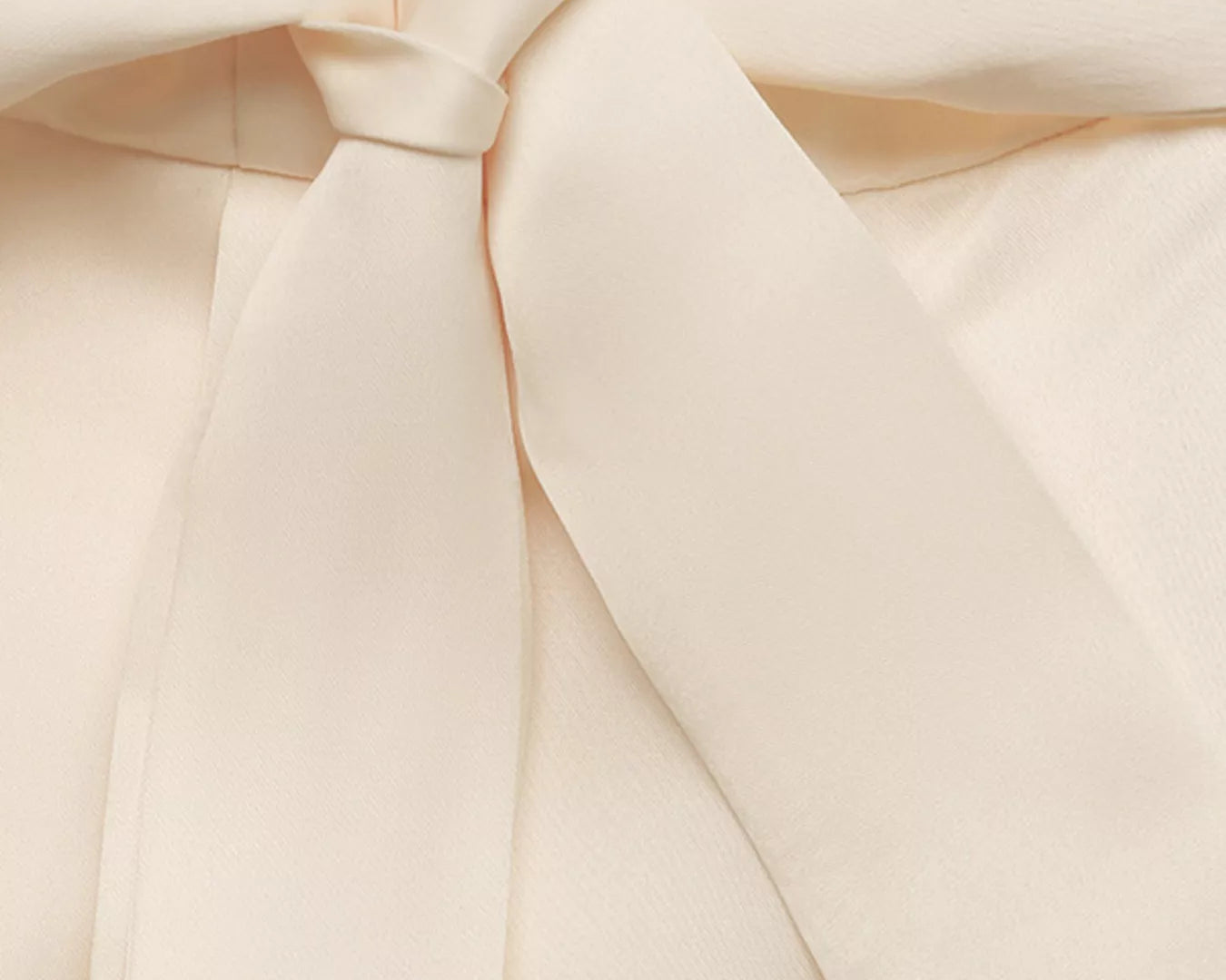 NEWYORKLISTED STYLE COLLECTION: Close-up of a cream-colored fabric with a bow detail