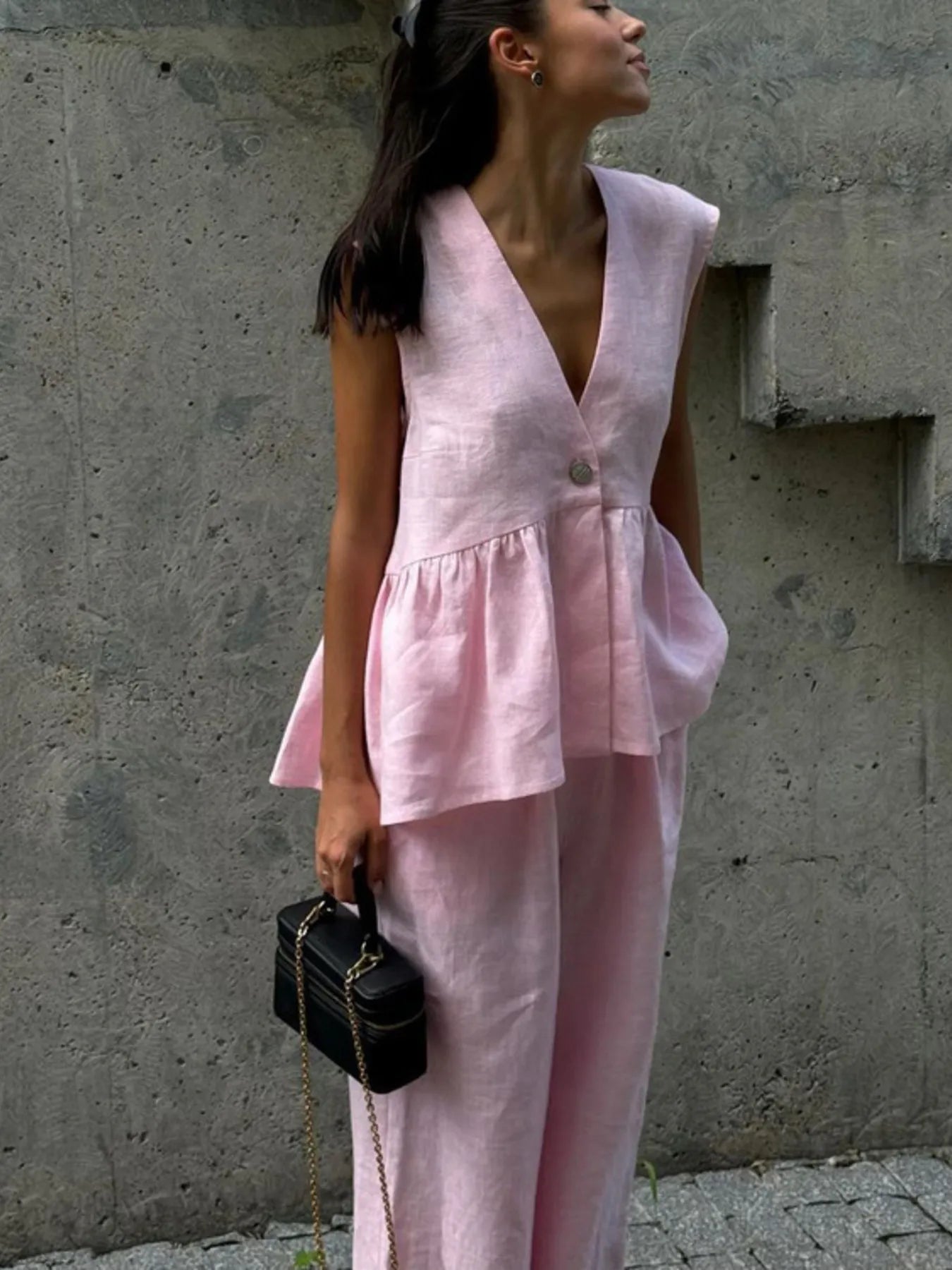 NEWYORKLISTED female model wearing a pink outfit against a gray wall