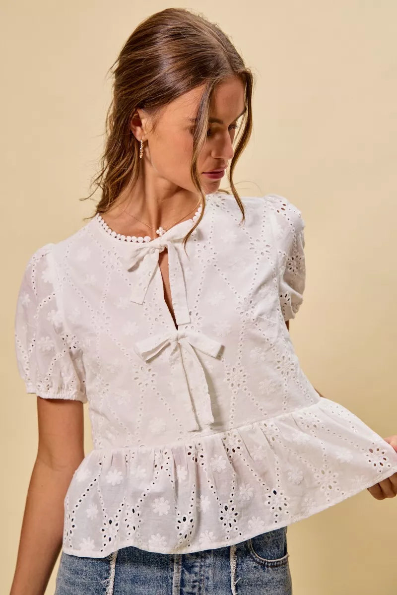 NEWYORKLISTED STYLE COLLECTION: Woman wearing a white lace blouse with a beige background