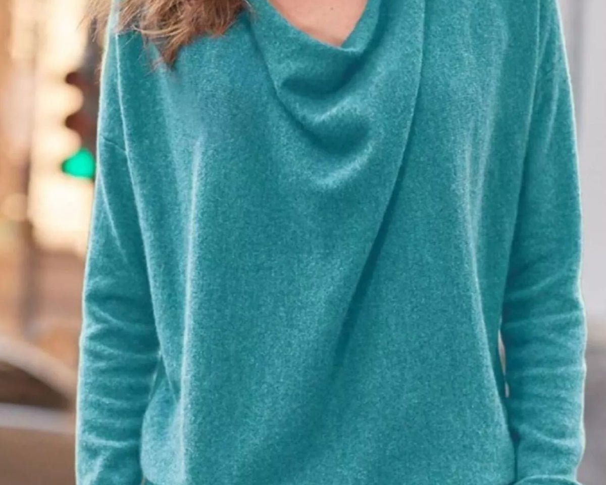 NEWYORKLISTED STYLE COLLECTION: Person wearing a teal sweater with a blurred background
