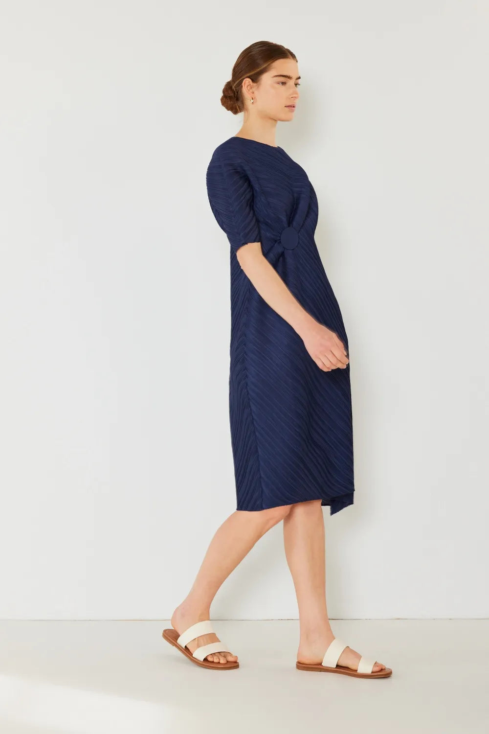 Woman wearing a navy blue dress against a white background: NEWYORKLISTED STYLE COLLECTION