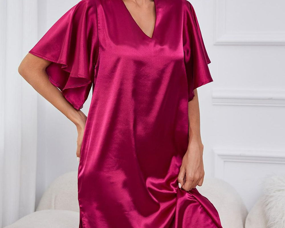 NEWYORKLISTED Intimate Apparel: Woman wearing a pink satin nightgown in a room with white walls and furniture.