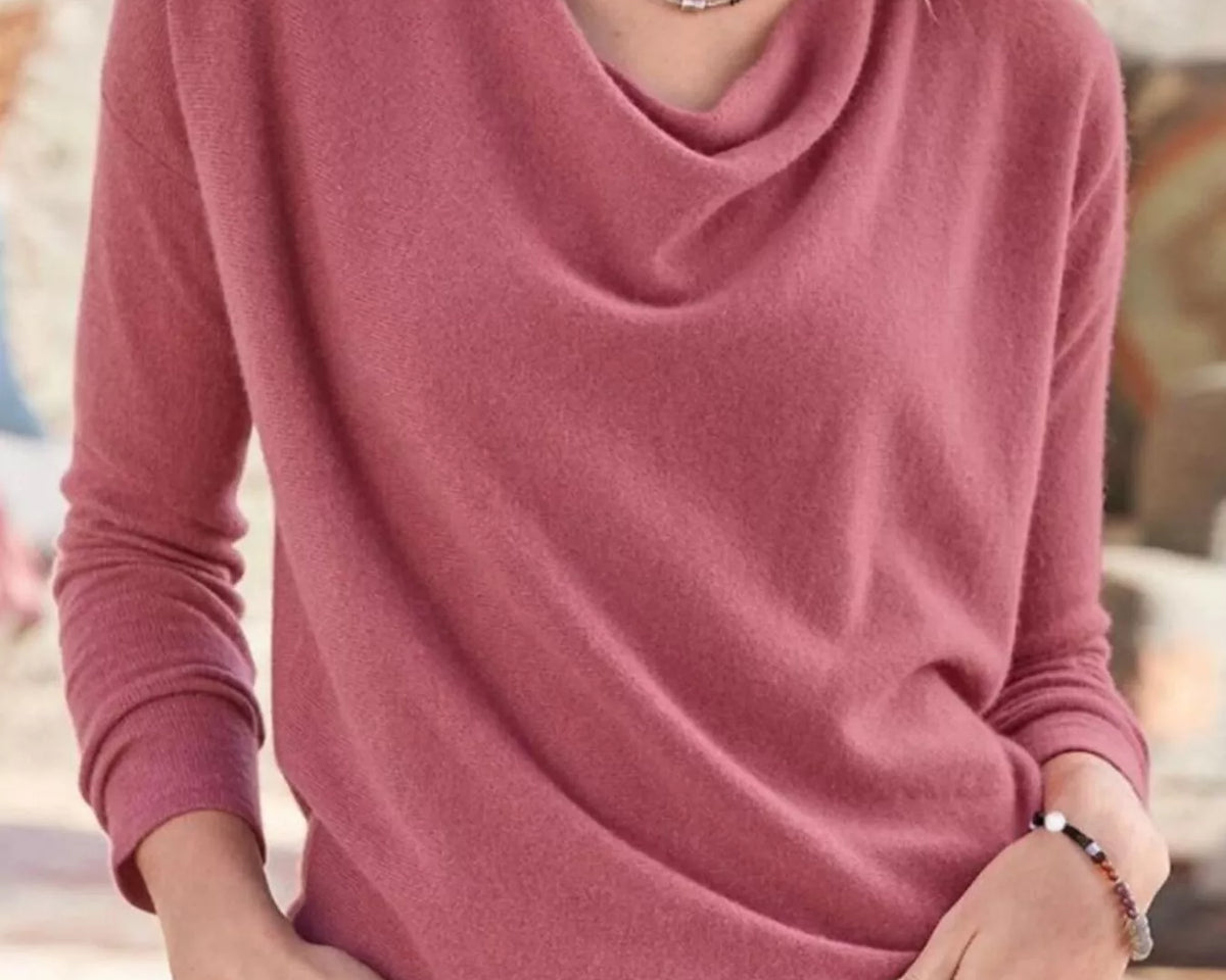 NEWYORKLISTED STYLE COLLECTION: Person wearing a pink long-sleeve top with a blurred background