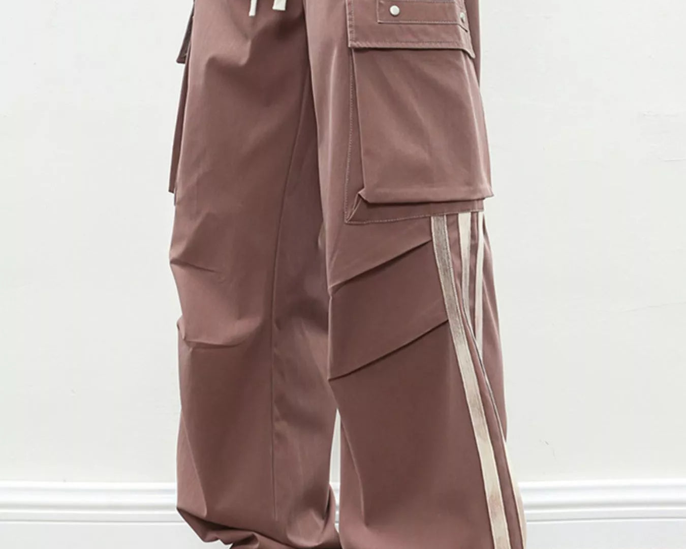 NEWYORKLISTED ATLAS MEN's COLLECTION: Brown cargo pants with white stripes worn by a person on a plain background